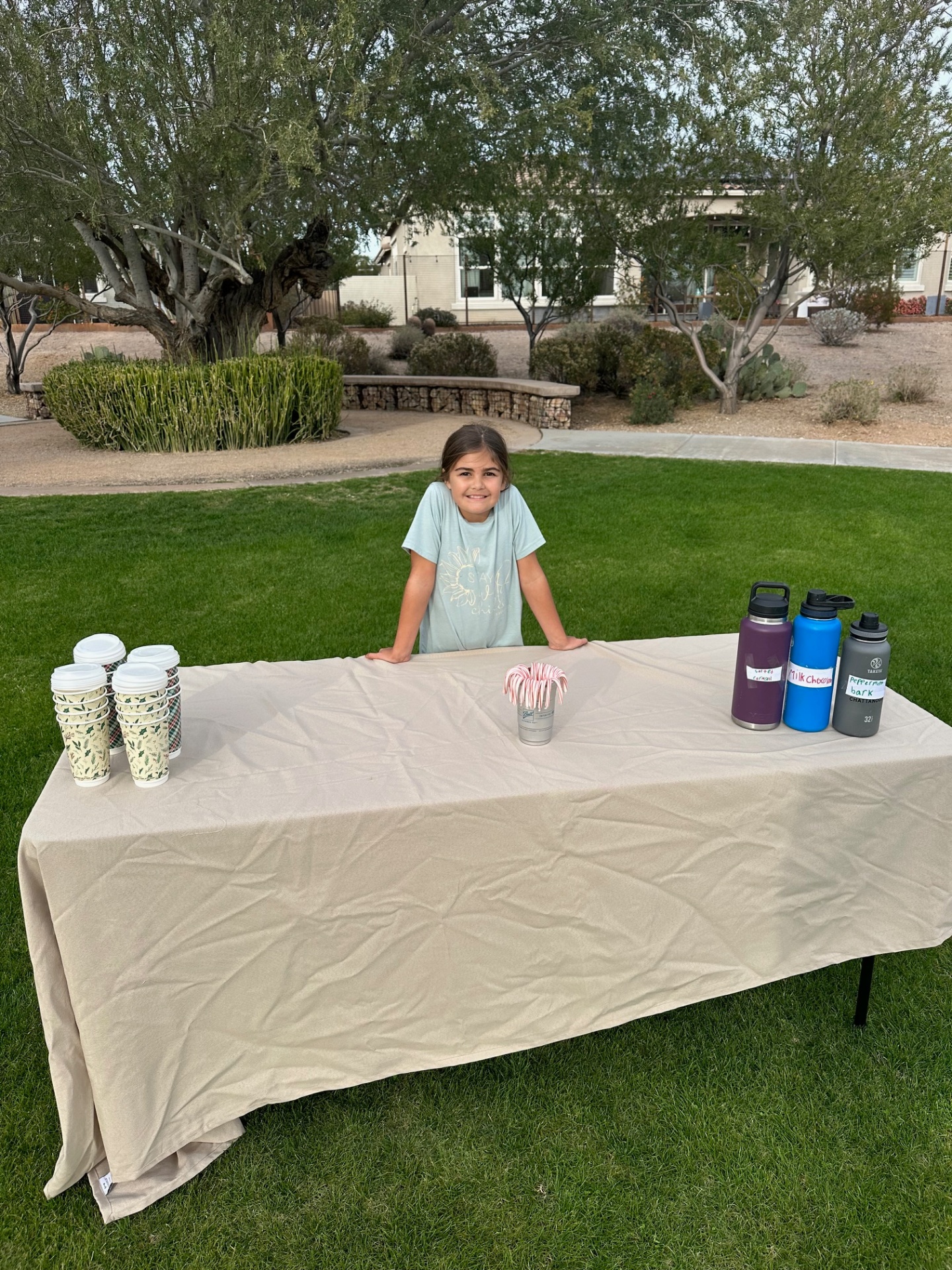 Dylan standing behind her hot cocoa stand, ready for customers